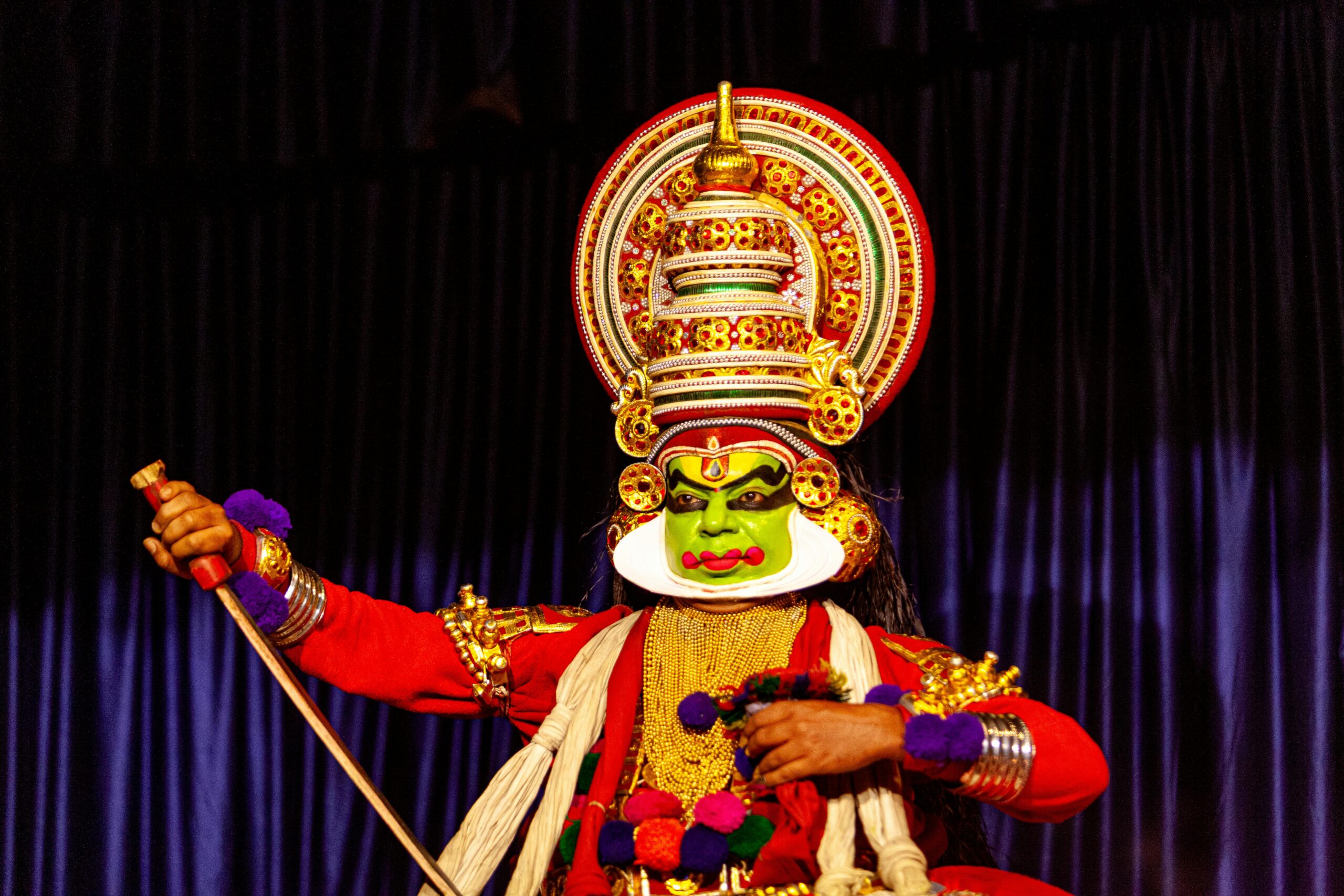 Colorful Kathakali dancer in traditional attire performing in Kumily, Kerala, India.